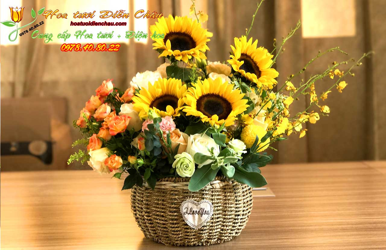Một mẫu giỏ hoa hướng dương tròn đầy, kết hợp nhiều bông hoa vàng rực rỡ, thích hợp làm quà tặng hoặc trang trí.